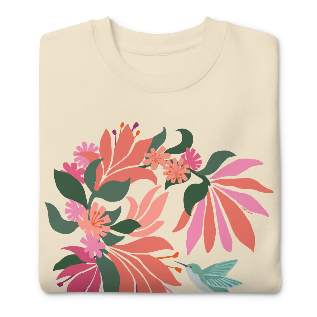 Hummingbird among coral tropical flowers on a crewneck sweatshirt in vintage white, folded close-up of the design – Kate Spain design