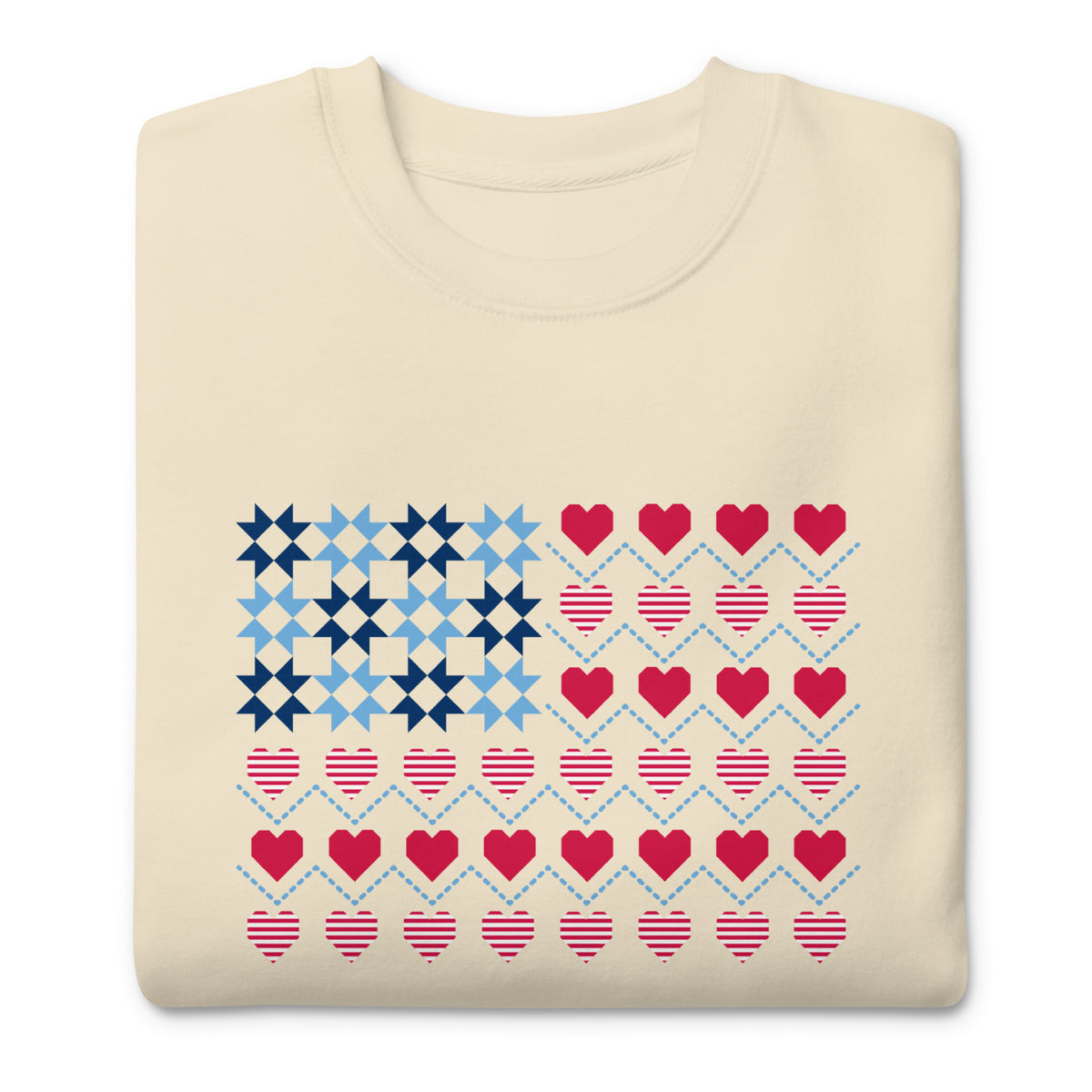 United We Quilt patchwork flag with quilt-block stars and heart stripes on a crewneck sweatshirt in vintage white, folded close-up of the design – Kate Spain design for Pat Sloan