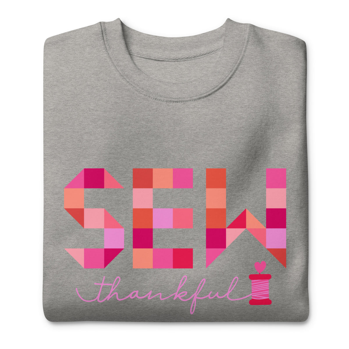 Sew Thankful patchwork lettering with a heart-topped thread spool on a crewneck sweatshirt in athletic grey, folded close-up of the design – Kate Spain design for Pat Sloan
