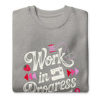 Work in Progress script lettering with sewing icons on a premium sweatshirt in athletic grey, folded close-up of the design – Kate Spain design for Pat Sloan