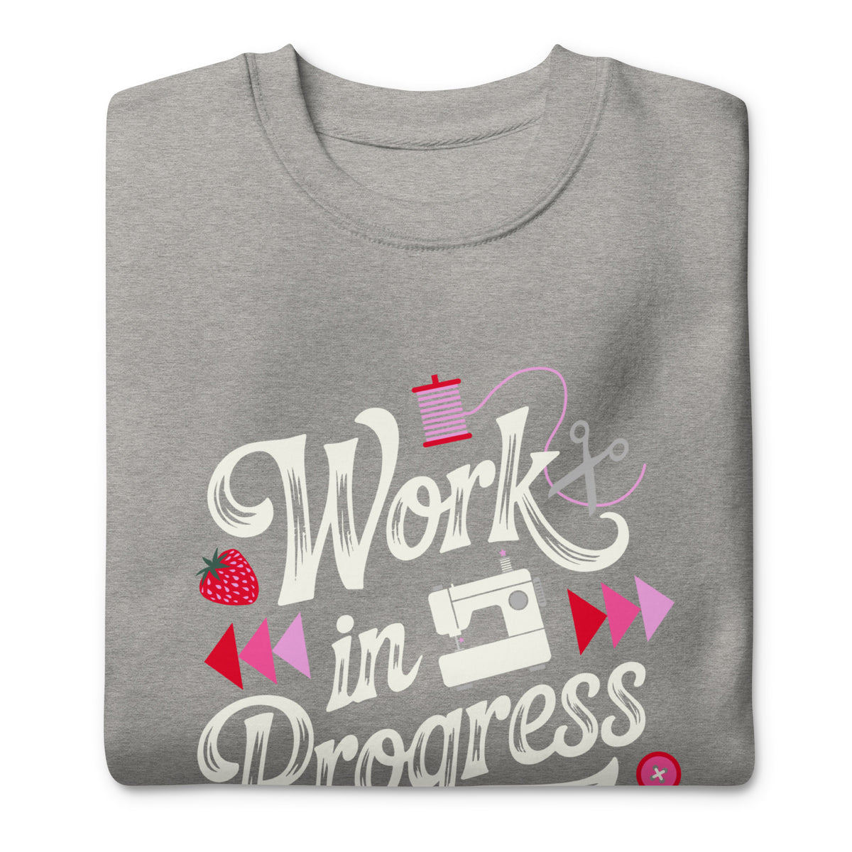 Work in Progress script lettering with sewing icons on a premium sweatshirt in athletic grey, folded close-up of the design – Kate Spain design for Pat Sloan