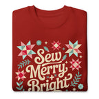 Sew Merry + Bright lettering with quilt stars and holly on a premium sweatshirt in cardinal red, folded close-up of the design – Kate Spain design for Pat Sloan