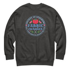 Fabric Curator Society of Stashers badge with a tomato pincushion on a crewneck sweatshirt in charcoal grey, front view – Kate Spain design for Pat Sloan