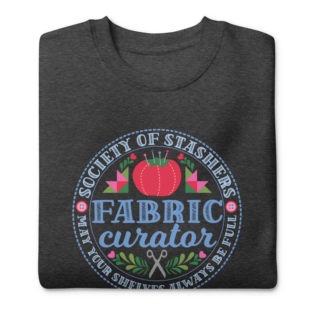 Fabric Curator Society of Stashers badge with a tomato pincushion on a crewneck sweatshirt in charcoal grey, folded close-up of the design – Kate Spain design for Pat Sloan