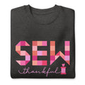 Sew Thankful patchwork lettering with a heart-topped thread spool on a crewneck sweatshirt in charcoal grey, folded close-up of the design – Kate Spain design for Pat Sloan