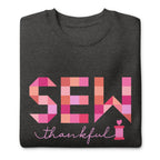Sew Thankful patchwork lettering with a heart-topped thread spool on a crewneck sweatshirt in charcoal grey, folded close-up of the design – Kate Spain design for Pat Sloan