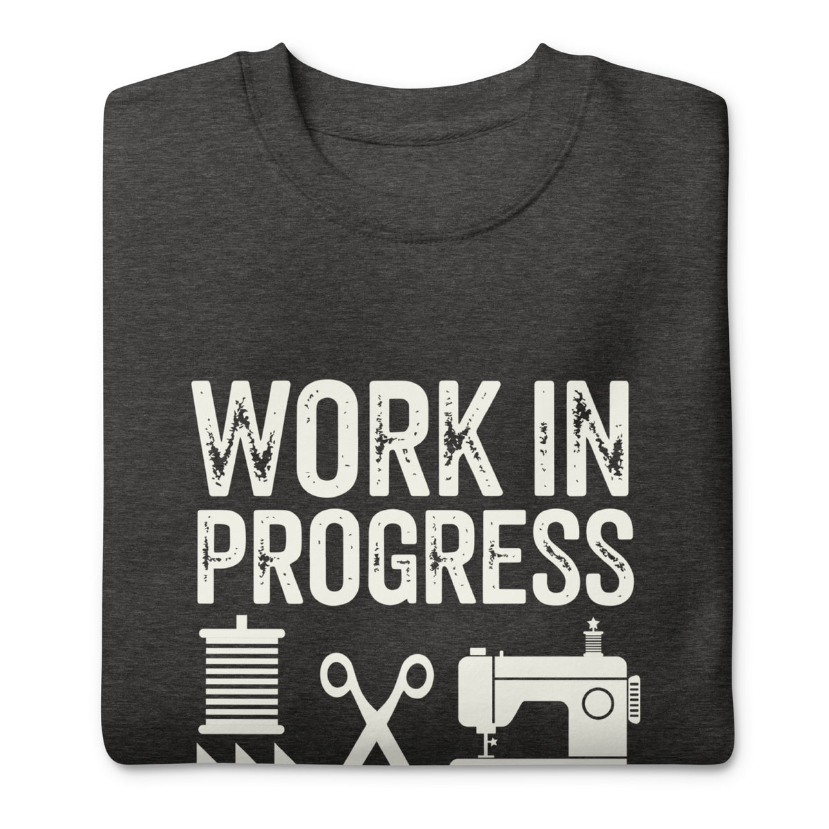 Work in Progress lettering with sewing icons on a premium sweatshirt in charcoal grey, folded close-up of the design – Kate Spain design for Pat Sloan