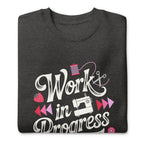Work in Progress script lettering with sewing icons on a premium sweatshirt in charcoal grey, folded close-up of the design – Kate Spain design for Pat Sloan