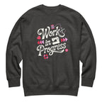 Work in Progress script lettering with sewing icons on a premium sweatshirt in charcoal grey, front view – Kate Spain design for Pat Sloan