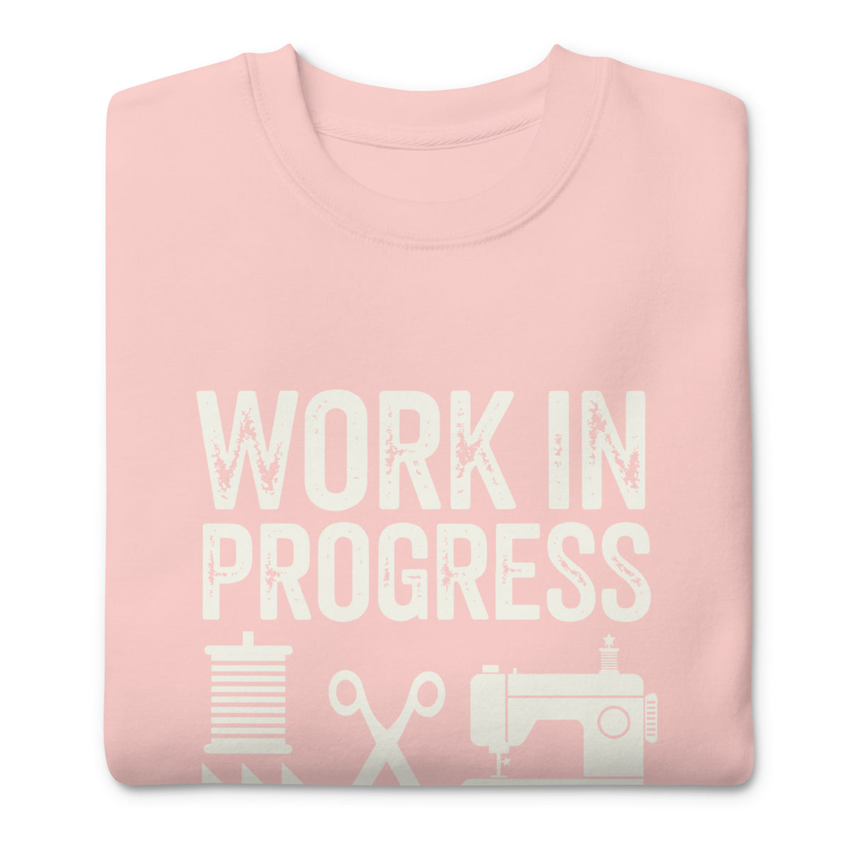 Work in Progress lettering with sewing icons on a premium sweatshirt in pink, folded close-up of the design – Kate Spain design for Pat Sloan