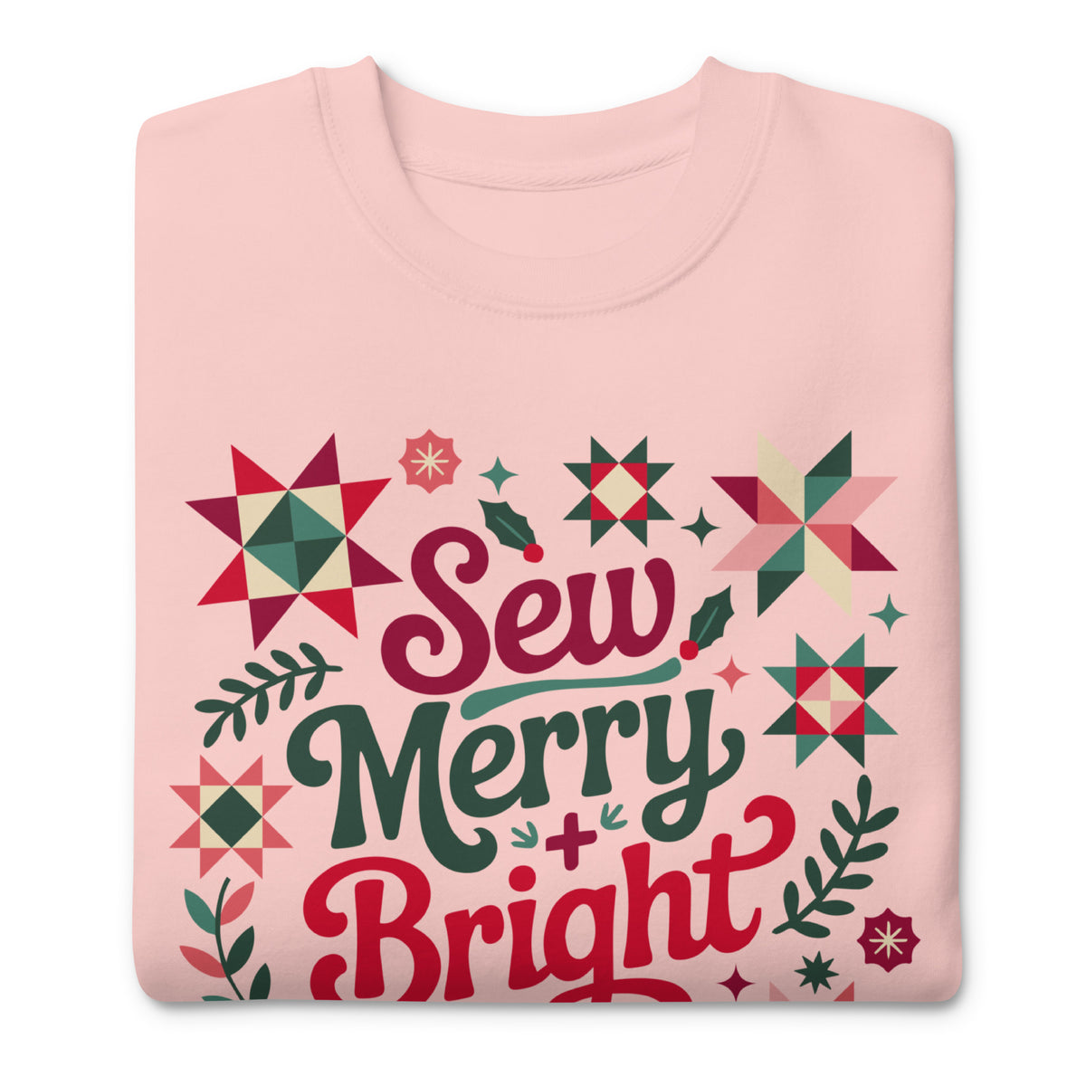 Sew Merry + Bright lettering with quilt stars and holly on a premium sweatshirt in pink, folded close-up of the design – Kate Spain design for Pat Sloan
