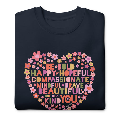 Be You floral heart of inspirational words on a premium sweatshirt in navy, folded close-up of the design – Kate Spain design