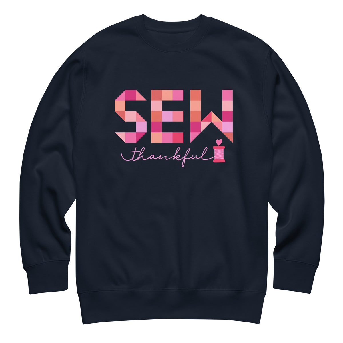 Sew Thankful patchwork lettering with a heart-topped thread spool on a crewneck sweatshirt in navy, front view – Kate Spain design for Pat Sloan