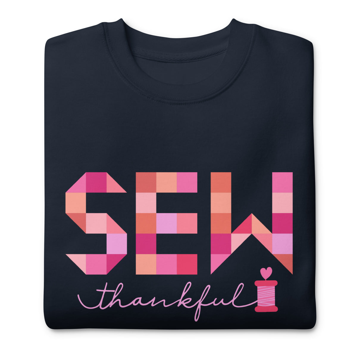 Sew Thankful patchwork lettering with a heart-topped thread spool on a crewneck sweatshirt in navy, folded close-up of the design – Kate Spain design for Pat Sloan