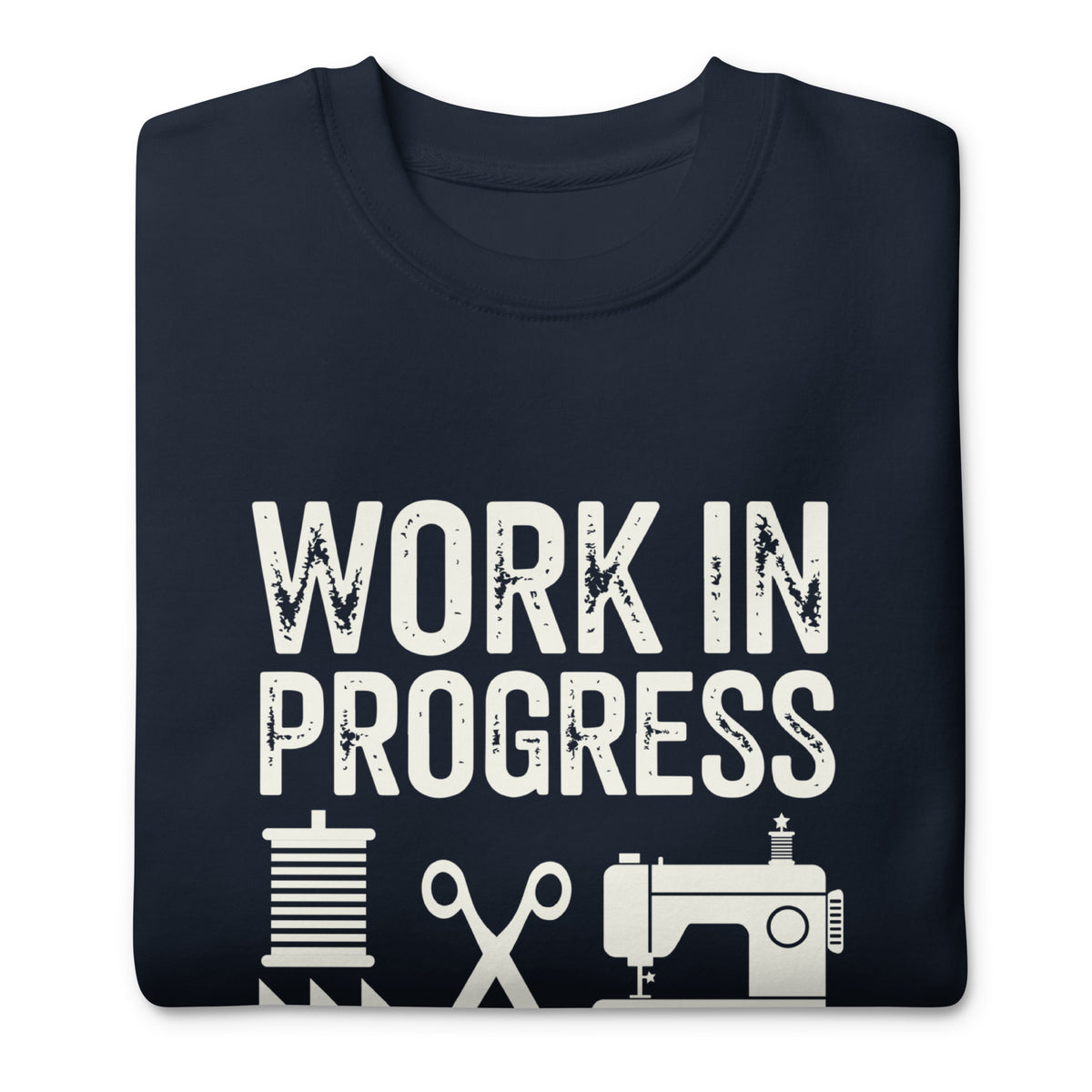 Work in Progress lettering with sewing icons on a premium sweatshirt in navy, folded close-up of the design – Kate Spain design for Pat Sloan