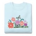 Bloom woodblock-style flowers with a butterfly, ladybug and bee on a crewneck sweatshirt in sky blue, folded close-up of the design – Kate Spain design