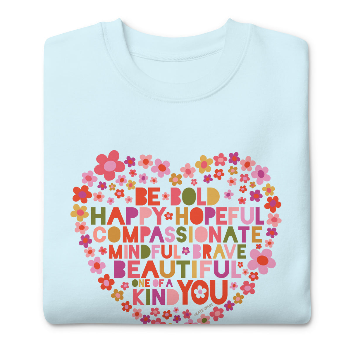 Be You floral heart of inspirational words on a premium sweatshirt in sky blue, folded close-up of the design – Kate Spain design