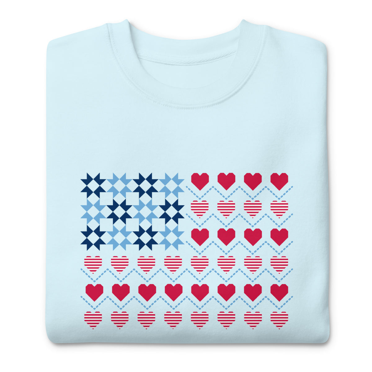 United We Quilt patchwork flag with quilt-block stars and heart stripes on a crewneck sweatshirt in sky blue, folded close-up of the design – Kate Spain design for Pat Sloan