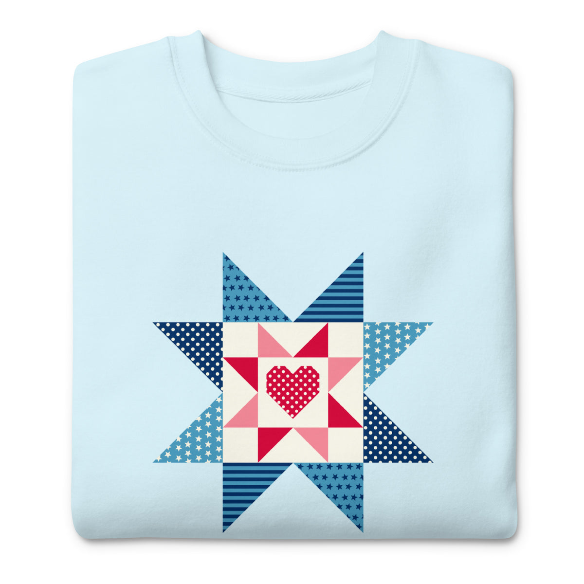 Liberty Love star quilt block with a heart in red, white and blue on a crewneck sweatshirt in sky blue, folded close-up of the design – Kate Spain design for Pat Sloan