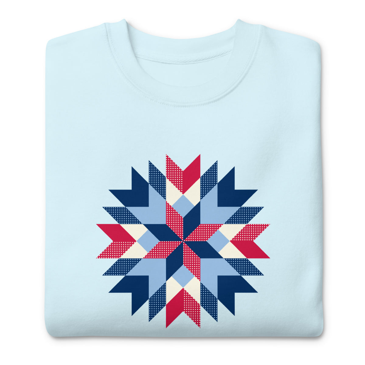 Barn Star quilt block in red, white and blue on a crewneck sweatshirt in sky blue, folded close-up of the design – Kate Spain design for Pat Sloan