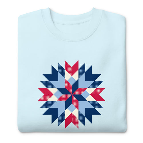 Barn Star quilt block in red, white and blue on a crewneck sweatshirt in sky blue, folded close-up of the design – Kate Spain design for Pat Sloan