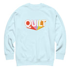 Moda QUILT logo with orange, pink, blue and yellow rays on a premium sweatshirt in sky blue, front view – Kate Spain design