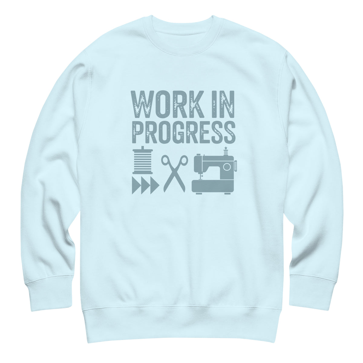 Work in Progress lettering with sewing icons on a premium sweatshirt in sky blue, front view – Kate Spain design for Pat Sloan
