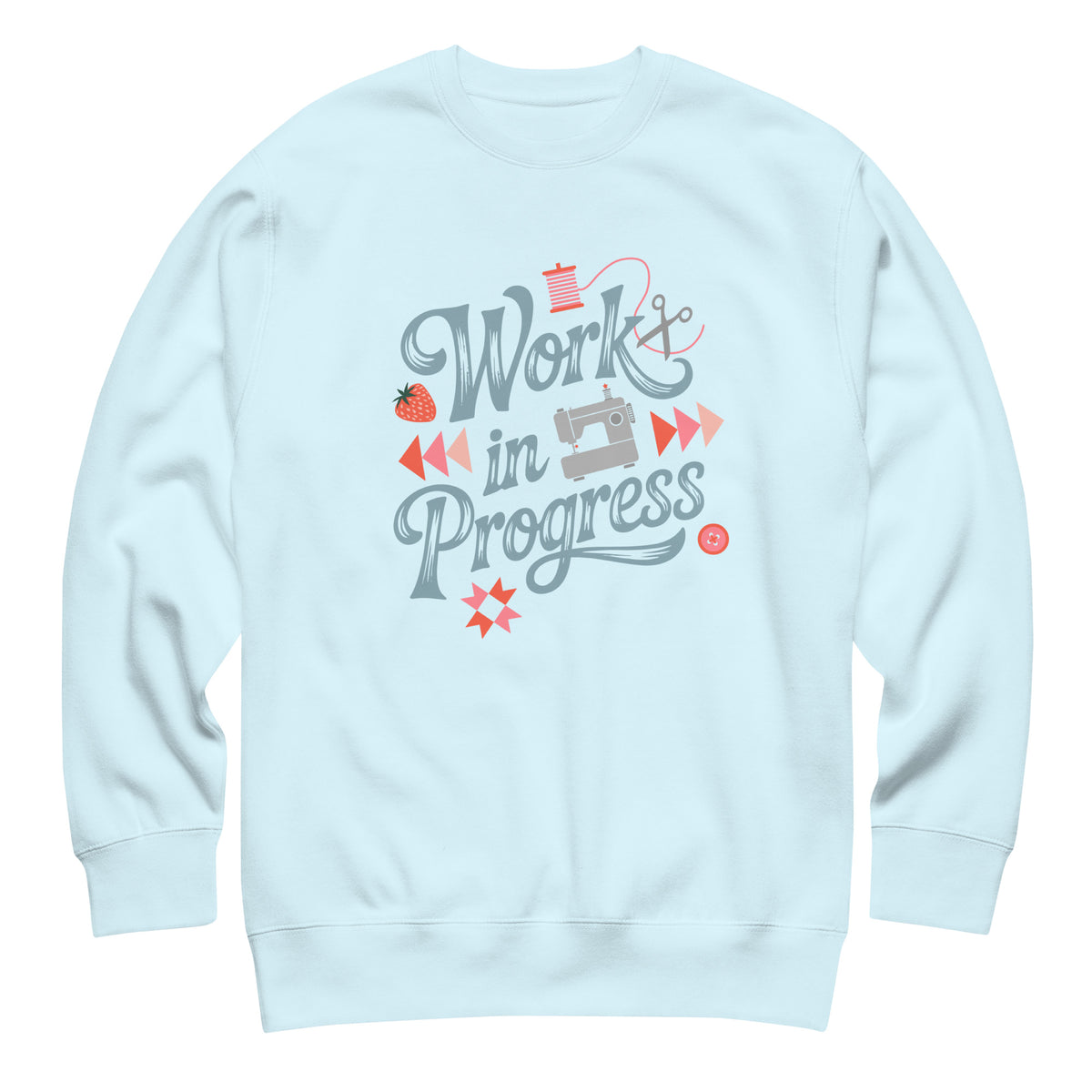 Work in Progress script lettering with sewing icons on a premium sweatshirt in sky blue, front view – Kate Spain design for Pat Sloan