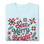Sew Merry + Bright lettering with quilt stars and holly on a premium sweatshirt in sky blue, folded close-up of the design – Kate Spain design for Pat Sloan