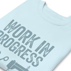 Work in Progress lettering with sewing icons on a premium sweatshirt in sky blue, close-up of the print – Kate Spain design for Pat Sloan