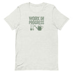 Garden Work in Progress distressed lettering with a shovel, pitchfork and watering can on a t-shirt in ash, front view – Kate Spain design