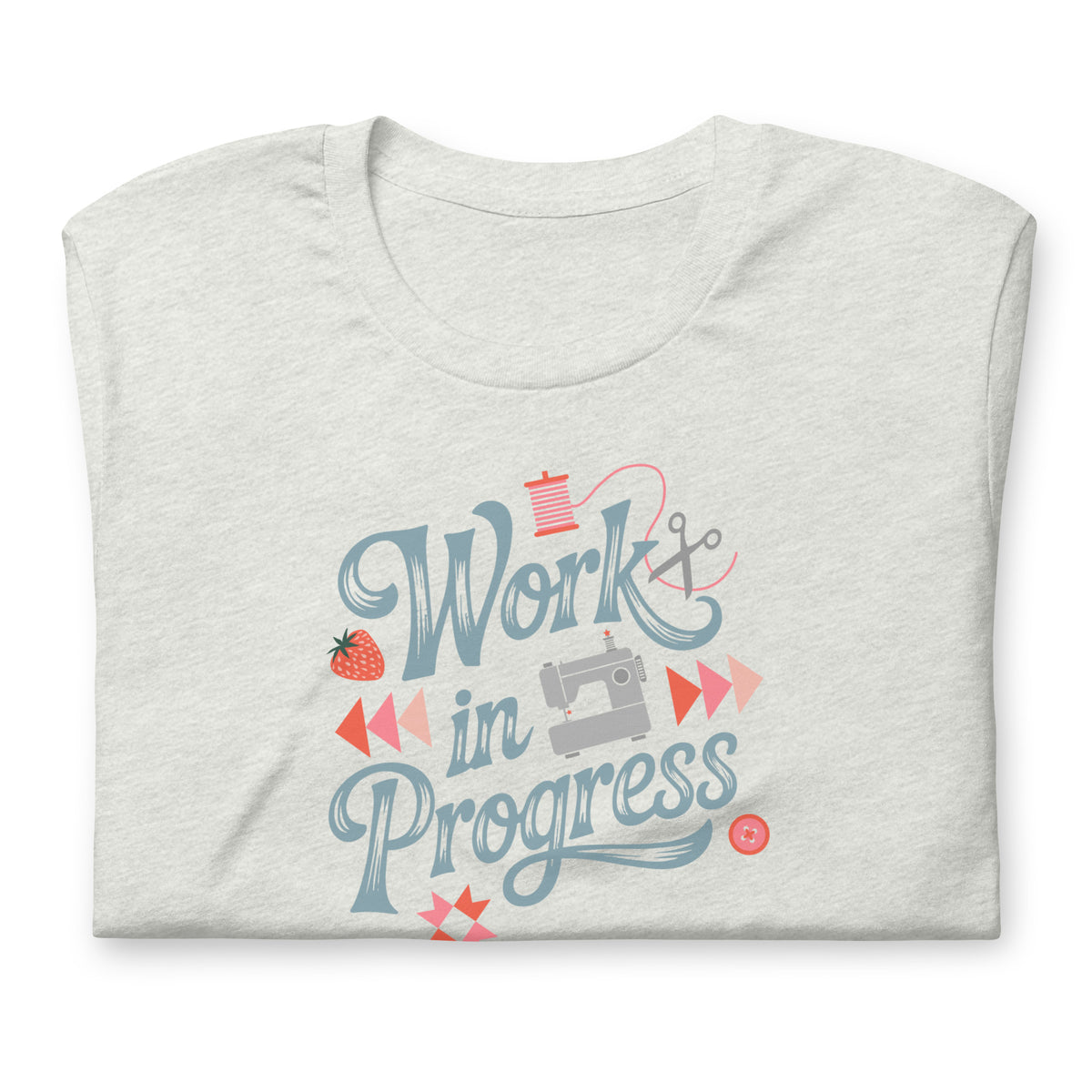 Work in Progress sewing design with flying geese, sewing machine, strawberry and thread spool on a t-shirt in ash, folded close-up of the design – Kate Spain design for Pat Sloan