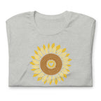 Golden sunflower with a heart center on a crewneck t-shirt in athletic heather grey, folded close-up of the design – Sunflowers in My Heart by Kate Spain