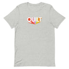 Moda QUILT logo with orange, pink, blue and yellow rays on a staple t-shirt in athletic heather grey, front view – Kate Spain design