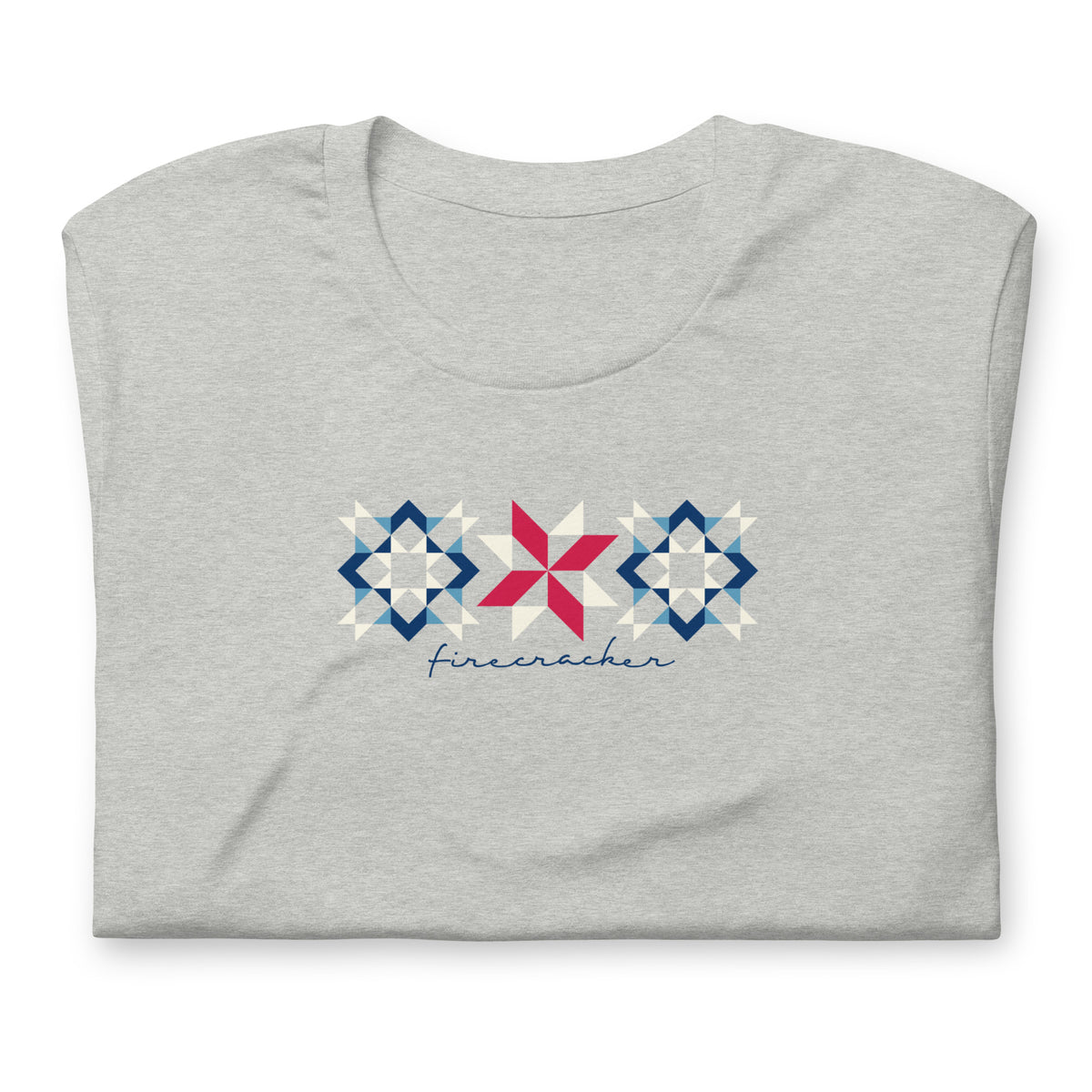 Firecracker quilt-block stars with script lettering in red, white and blue on a t-shirt in athletic heather grey, folded close-up of the design – Kate Spain design for Pat Sloan