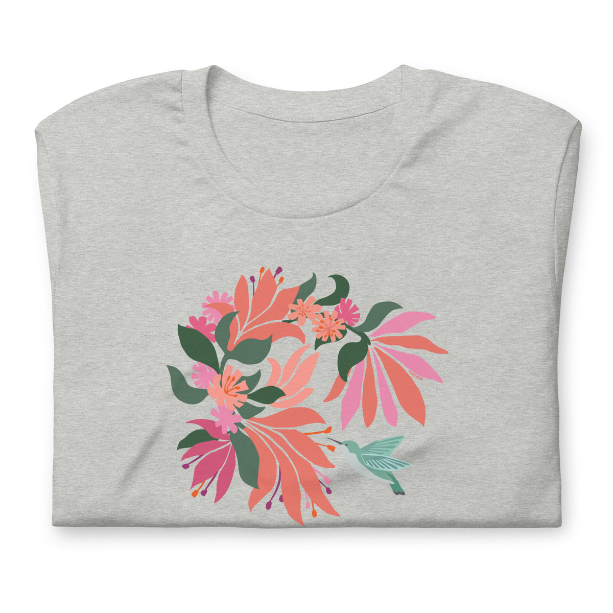 Hummingbird among coral tropical flowers on a t-shirt in athletic heather grey, folded close-up of the design – Kate Spain design