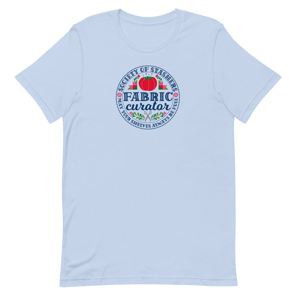 Fabric Curator Society of Stashers badge with a tomato pincushion on a t-shirt in light blue, front view – Kate Spain design for Pat Sloan