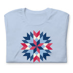 Barn Star quilt block in red, white and blue on a t-shirt in baby blue, folded close-up of the design – Kate Spain design for Pat Sloan