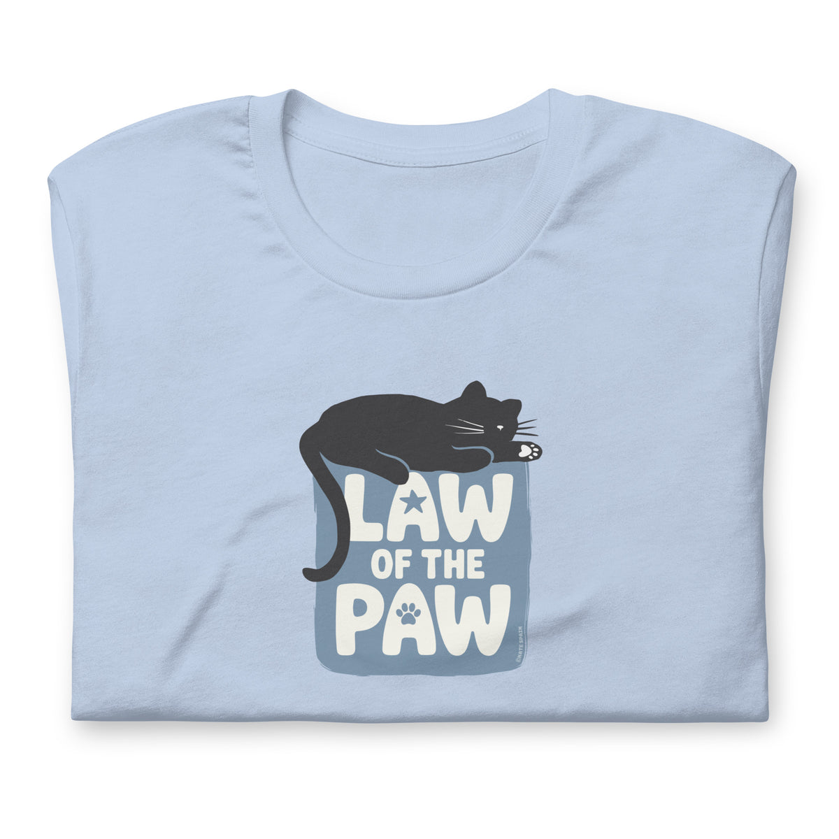 Law of the Paw® design with a cat napping on the logo on a t-shirt in light blue, folded close-up of the design – Kate Spain design