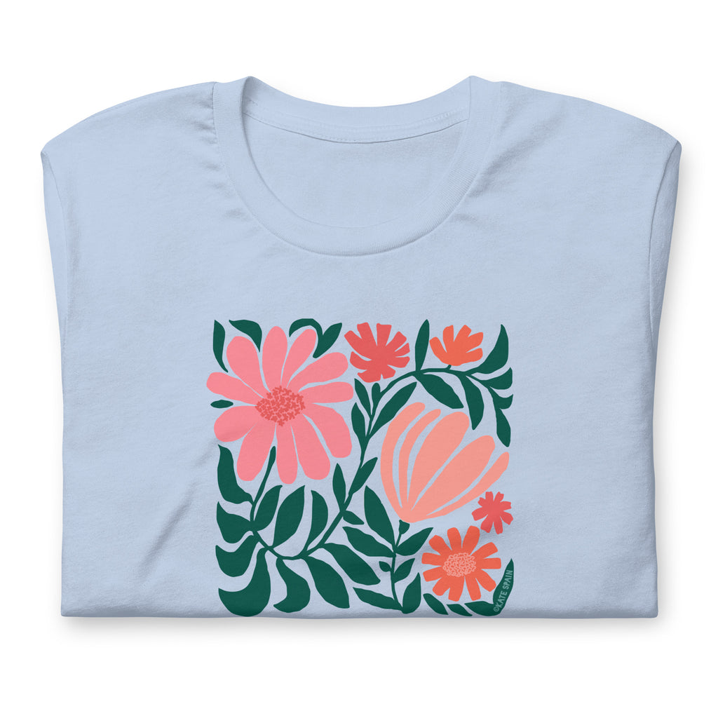 Botanica modern floral design with pink and coral blooms on a t-shirt in light blue, folded close-up of the design – Kate Spain design