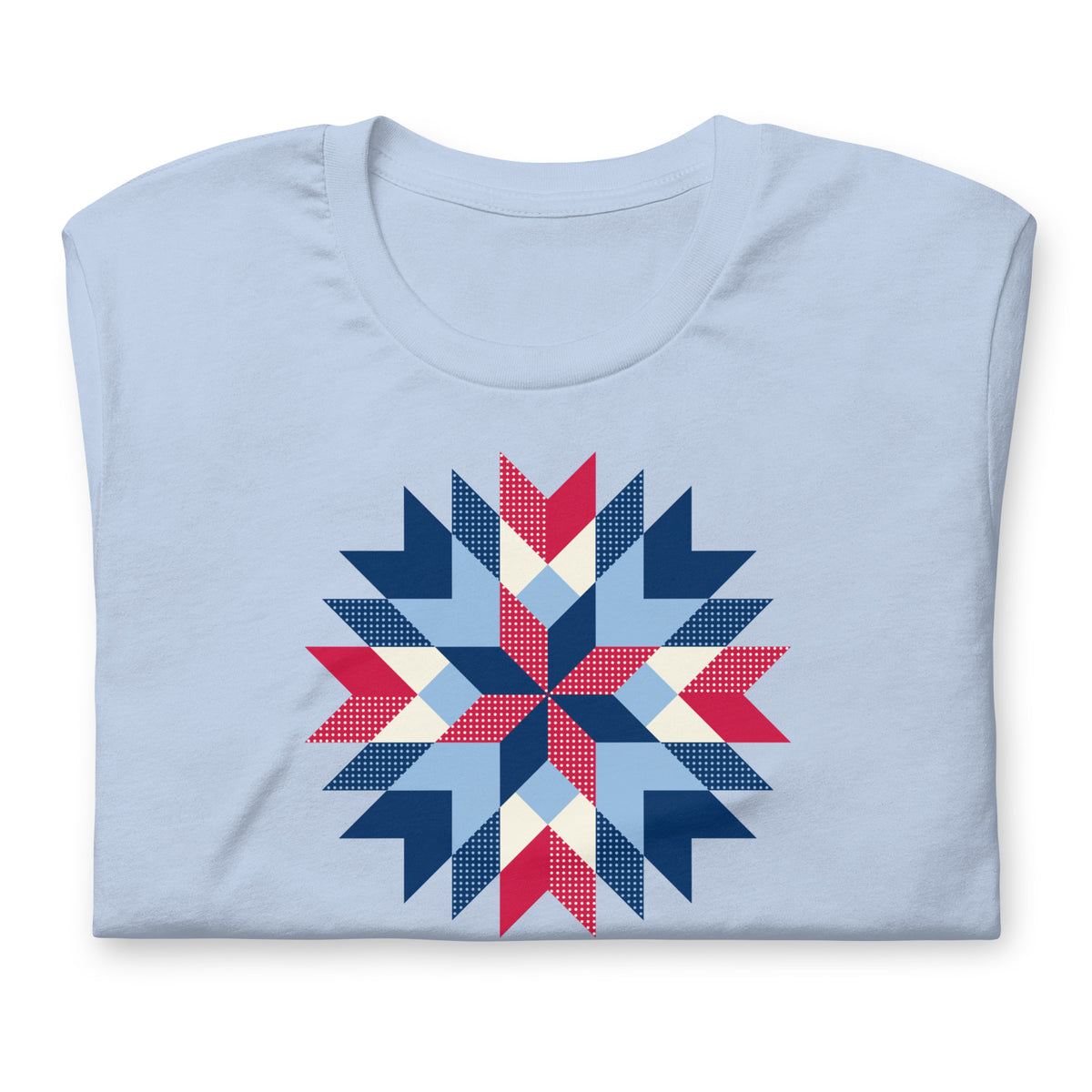 Barn Star quilt block in red, white and blue on a staple t-shirt in baby blue, folded close-up of the design – Kate Spain design for Pat Sloan