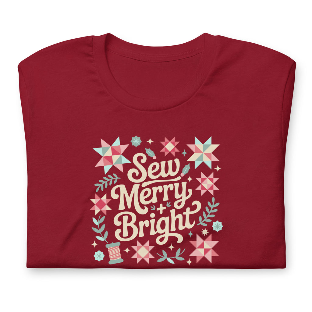 Sew Merry + Bright lettering with quilt stars and holly on a staple t-shirt in cardinal red, folded close-up of the design – Kate Spain design for Pat Sloan