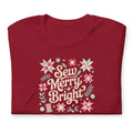 Sew Merry + Bright lettering with quilt stars and holly on a staple t-shirt in cardinal red, folded close-up of the design – Kate Spain design for Pat Sloan