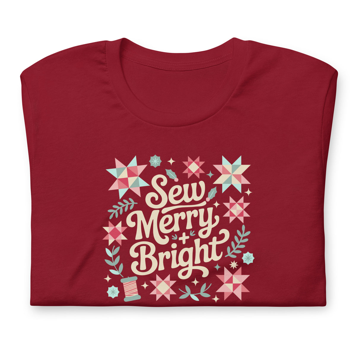 Sew Merry + Bright lettering with quilt stars and holly on a staple t-shirt in cardinal red, folded close-up of the design – Kate Spain design for Pat Sloan