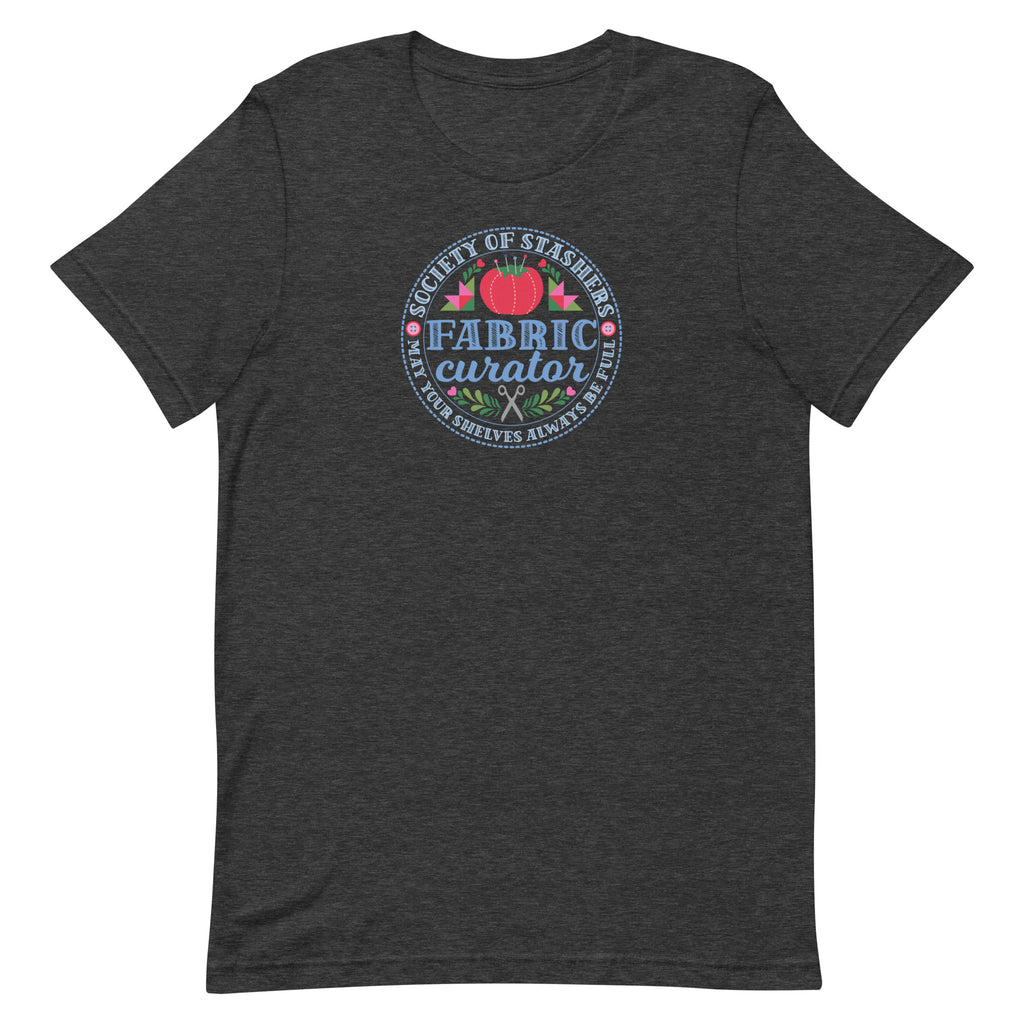 Fabric Curator Society of Stashers badge with a tomato pincushion on a t-shirt in dark grey heather, front view – Kate Spain design for Pat Sloan