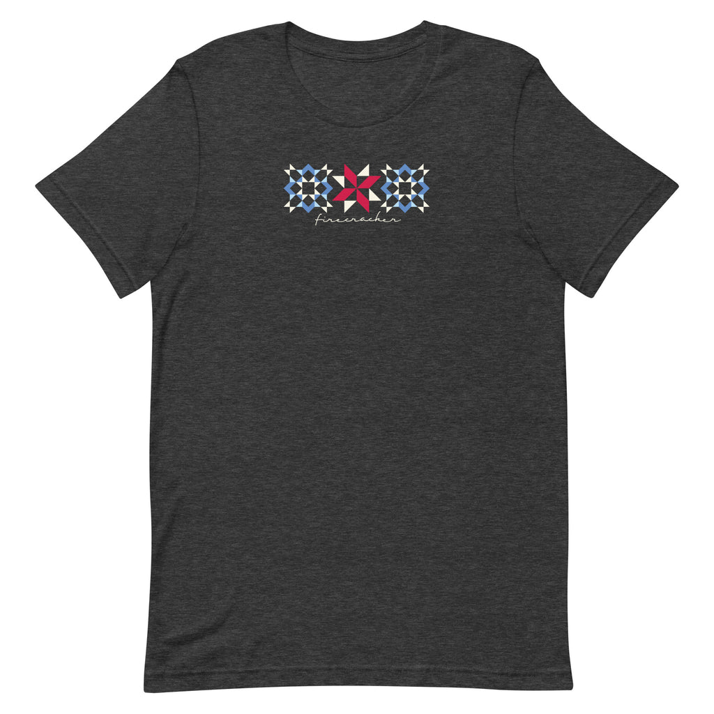 Firecracker quilt-block stars with script lettering in red, white and blue on a t-shirt in dark grey heather, front view – Kate Spain design for Pat Sloan