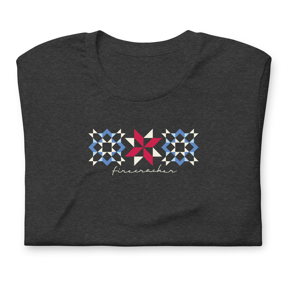 Firecracker quilt-block stars with script lettering in red, white and blue on a t-shirt in dark grey heather, folded close-up of the design – Kate Spain design for Pat Sloan