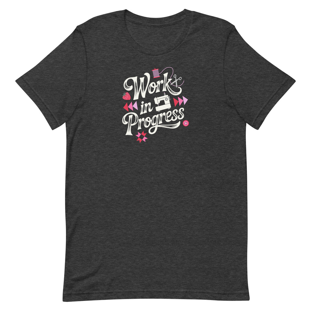 Work in Progress sewing design with flying geese, sewing machine, strawberry and thread spool on a t-shirt in dark grey heather, front view – Kate Spain design for Pat Sloan