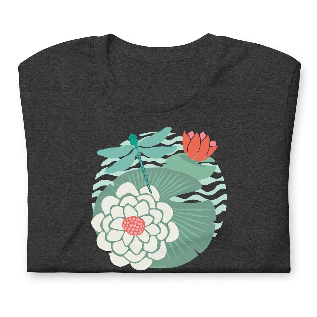 Dragonfly over water lilies and lily pads on a t-shirt in dark grey heather, folded close-up of the design – Kate Spain design