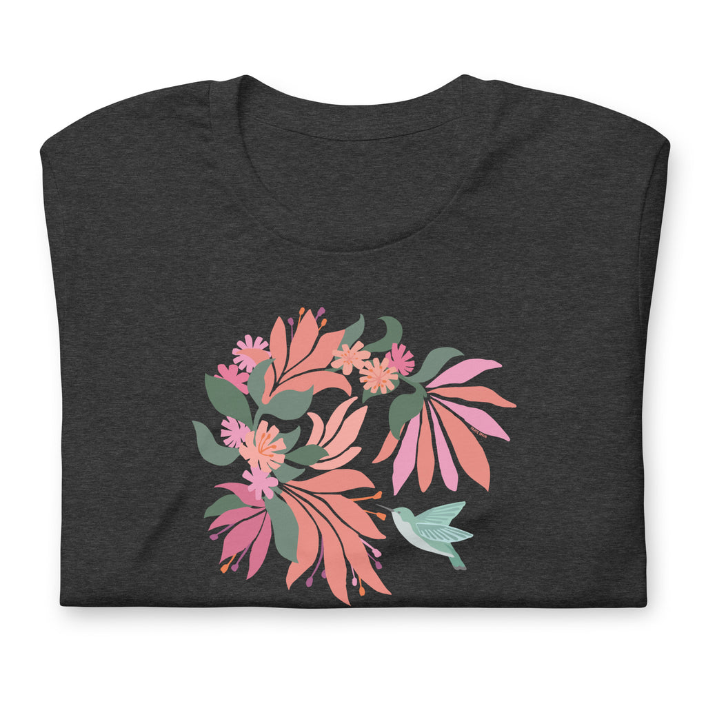 Hummingbird among coral tropical flowers on a t-shirt in dark grey heather, folded close-up of the design – Kate Spain design